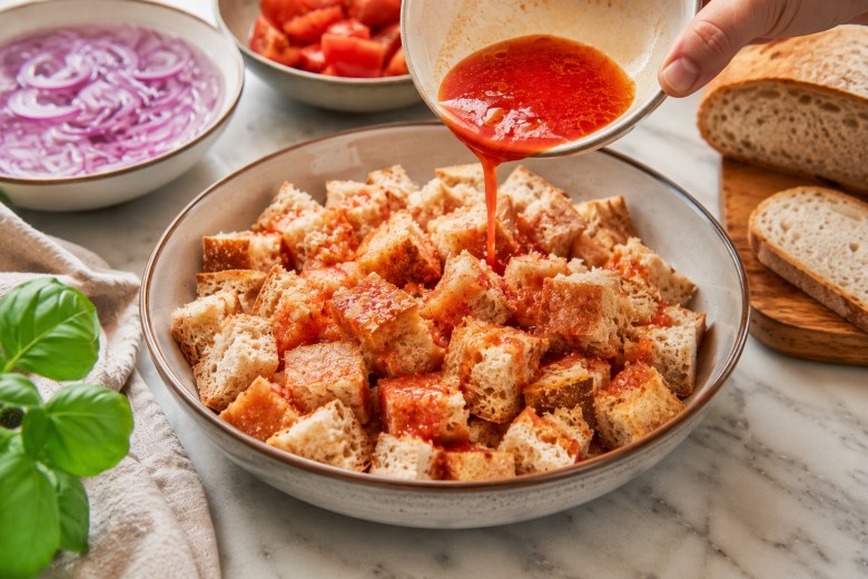 Tomatensaft für Panzanelle zufügen